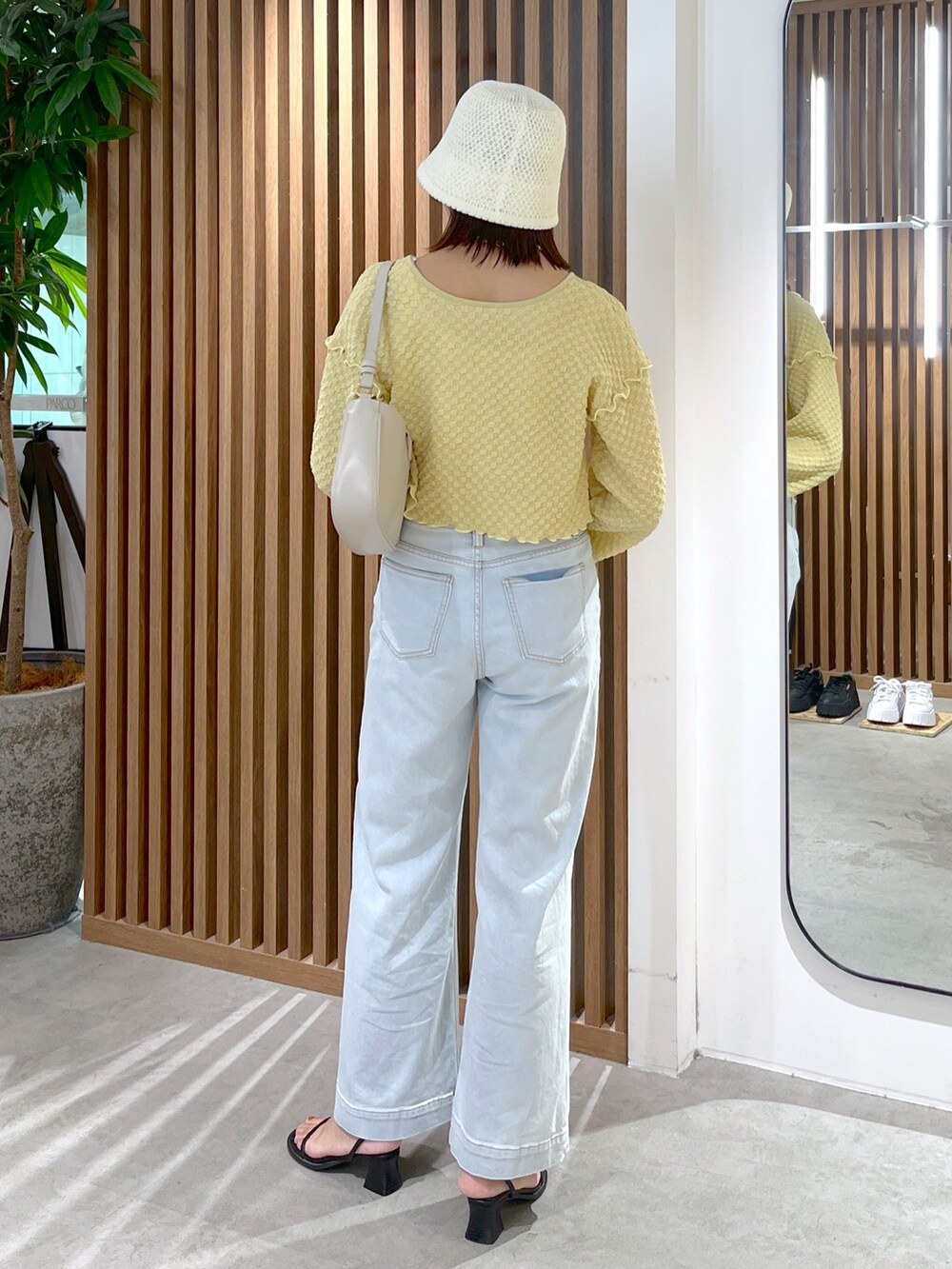 イエロー系のカーディガン/ボレロ、ブルー系のデニムパンツ、グレー系のショルダーバッグを着用したレディースの夏コーディネートの5枚目の写真