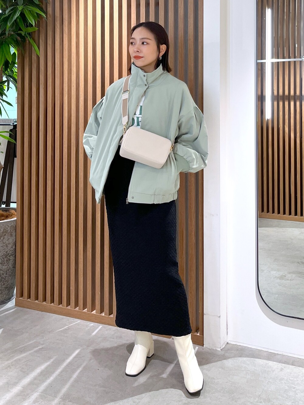 グリーン系のブルゾン、ホワイト系のTシャツ/カットソー、ホワイト系のボディバッグ/ウエストポーチを着用したレディースの春コーディネートの6枚目の写真