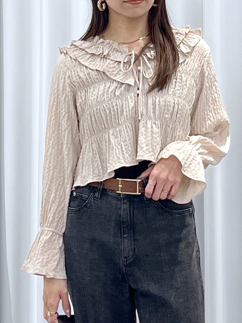 ベージュ系のシャツ/ブラウス、ブラウン系のトートバッグ、ブラック系のデニムパンツを着用したレディースの冬コーディネートの8枚目の写真