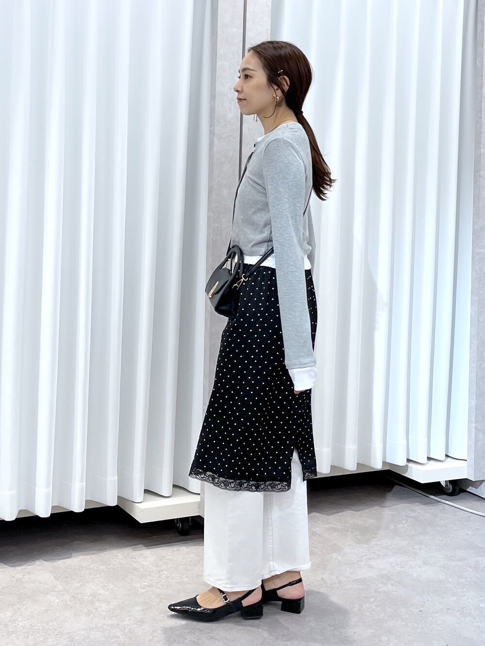 ブラック系のスカート、グレー系のTシャツ/カットソー、ホワイト系のデニムパンツを着用したレディースの春コーディネートの5枚目の写真