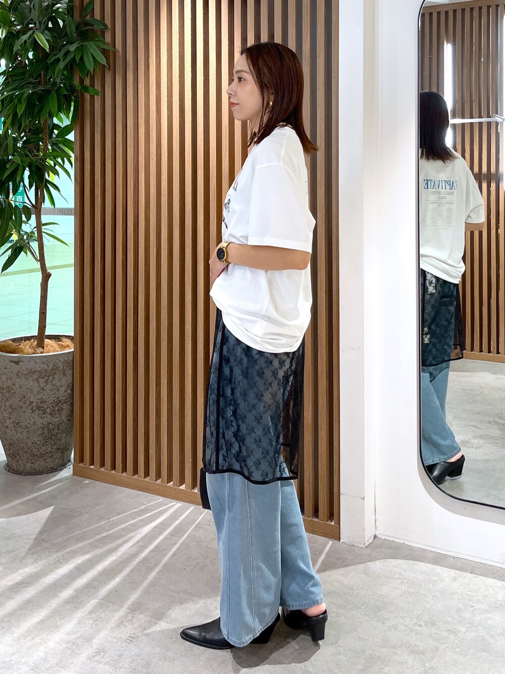 ホワイト系のTシャツ/カットソー、ブラック系のハンドバッグ、ブラック系のスカートを着用したレディースの秋コーディネートの4枚目の写真