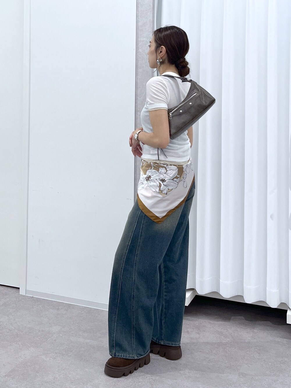 ホワイト系のTシャツ/カットソー、ブラウン系のショルダーバッグ、ブルー系のデニムパンツを着用したレディースの春コーディネートの4枚目の写真
