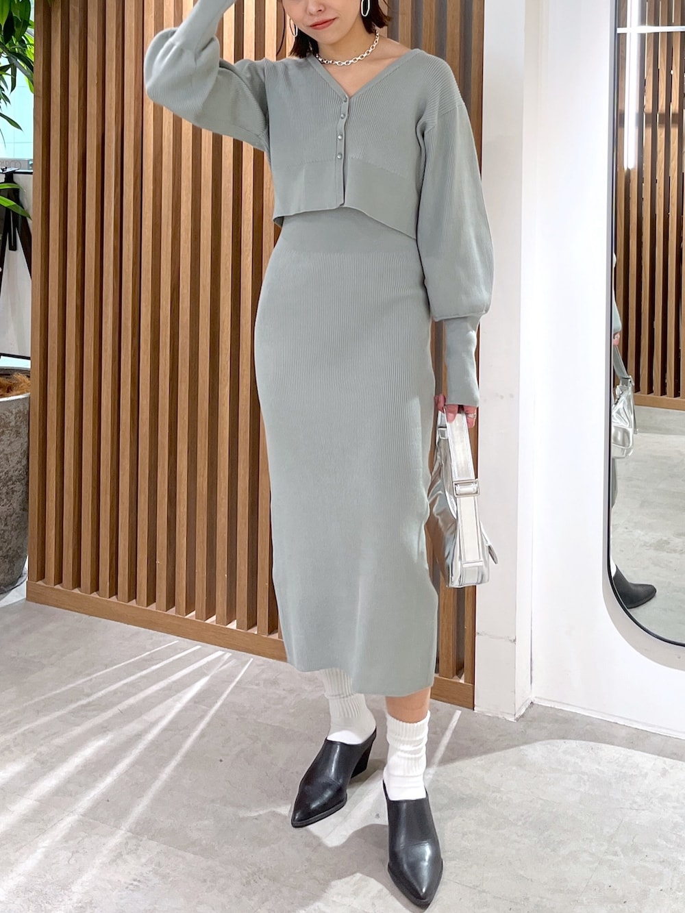 グリーン系のカーディガン/ボレロ、シルバー系のショルダーバッグ、グリーン系のワンピースを着用したレディースの冬コーディネートの6枚目の写真