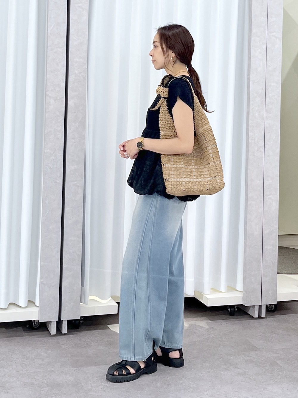 ブルー系のデニムパンツ、ブラック系のニット/セーターを着用したレディースの春コーディネートの3枚目の写真