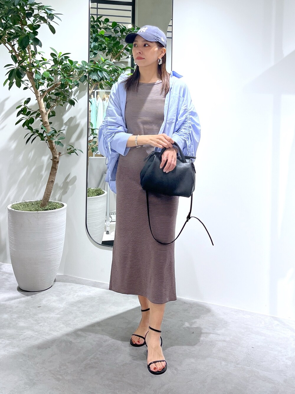 ブラウン系のワンピース、ブルー系のシャツ/ブラウス、ブラック系のショルダーバッグを着用したレディースの春コーディネートの3枚目の写真