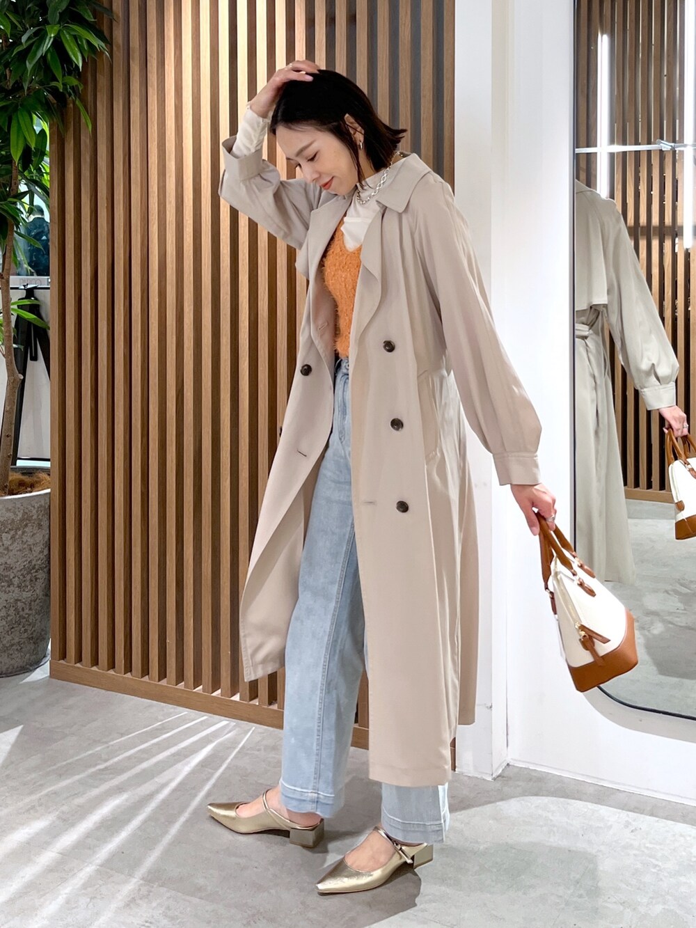 ブラウン系のショルダーバッグ、ホワイト系のTシャツ/カットソー、オレンジ系のベストを着用したレディースの春コーディネートの5枚目の写真