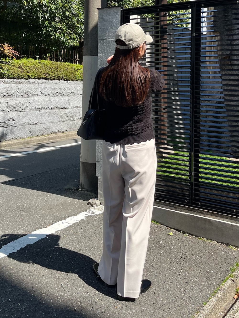 ブラック系のニット/セーター、ベージュ系のスラックス、ブラック系のパンプスを着用したレディースの春コーディネートの4枚目の写真