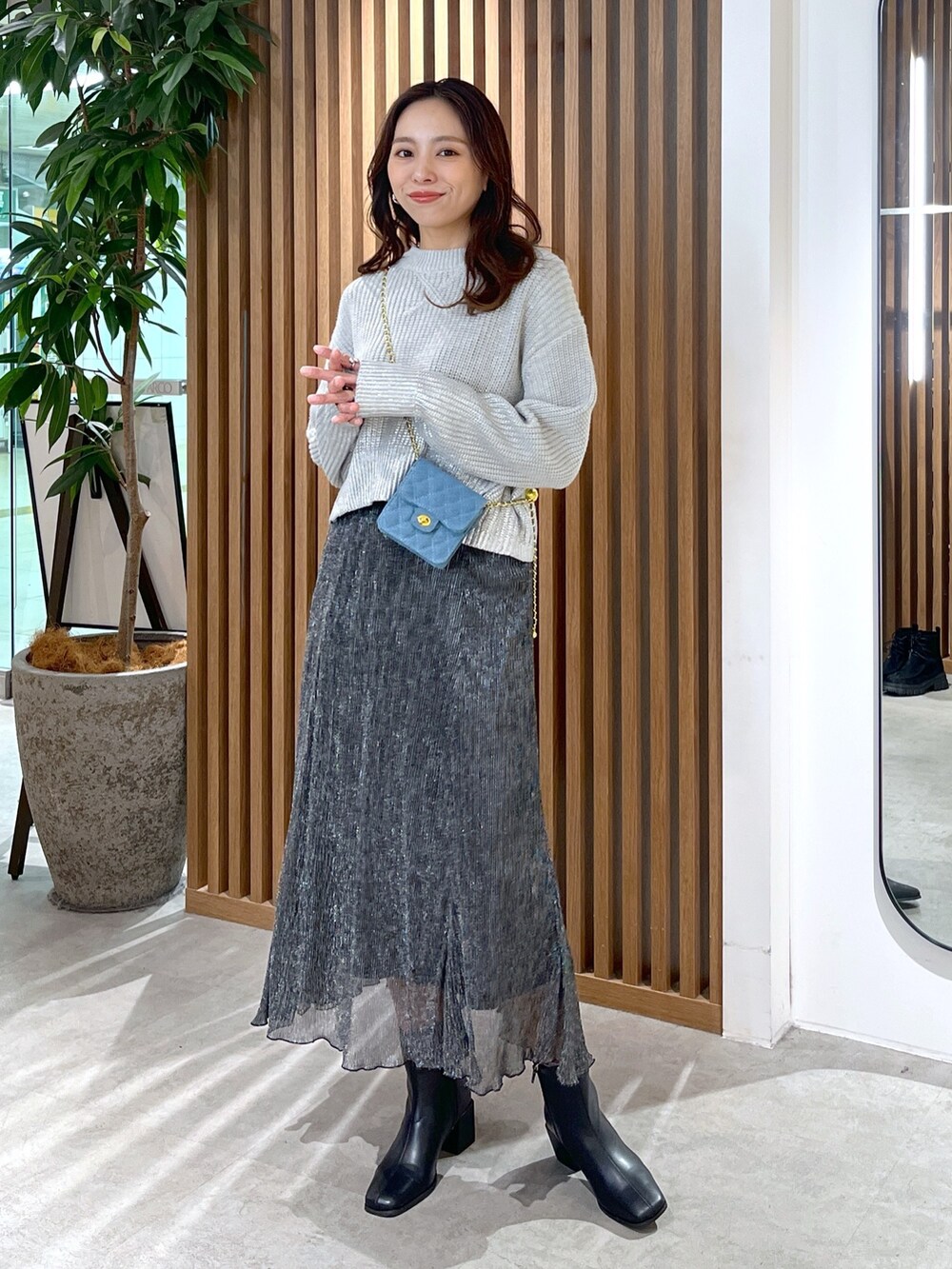 グレー系のニット/セーター、ブルー系のショルダーバッグ、ブラック系のスカートを着用したレディースの冬コーディネートの9枚目の写真