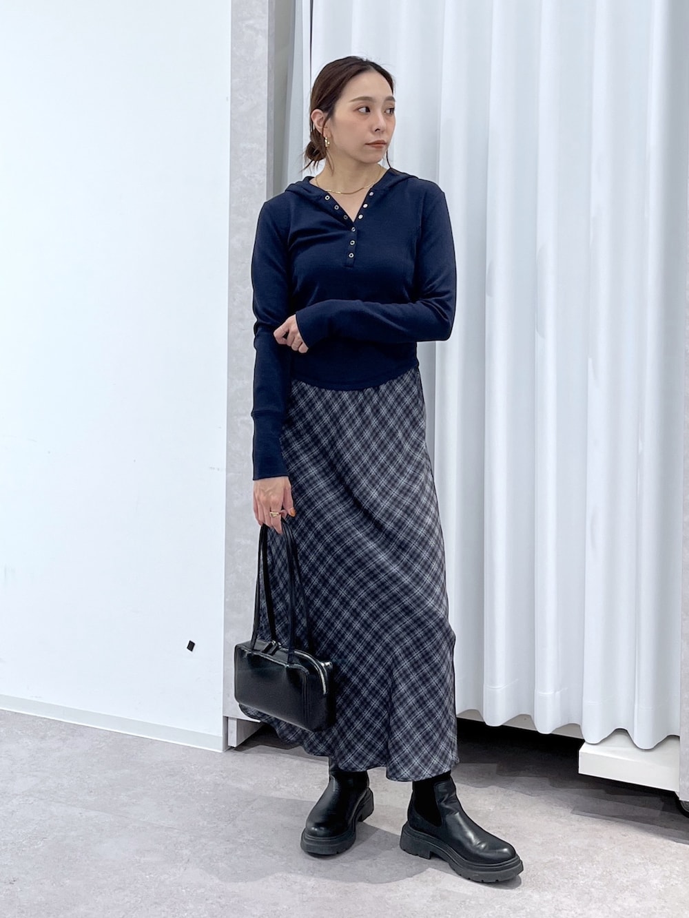 ブルー系のTシャツ/カットソー、グレー系のスカート、ブラック系のショルダーバッグを着用したレディースの春コーディネートの2枚目の写真