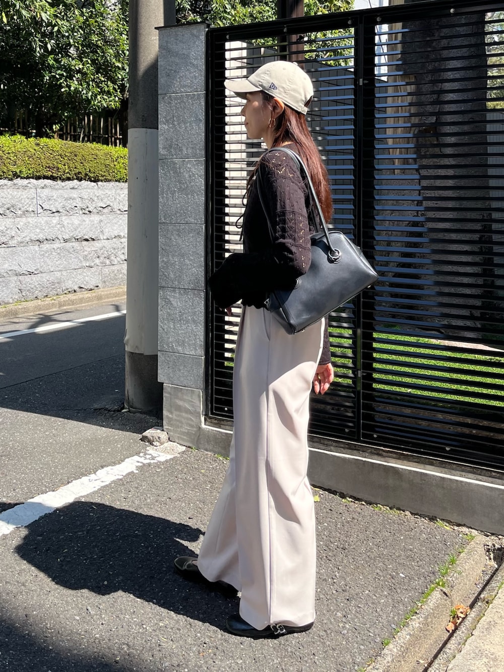 ブラック系のニット/セーター、ベージュ系のスラックス、ブラック系のパンプスを着用したレディースの春コーディネートの5枚目の写真