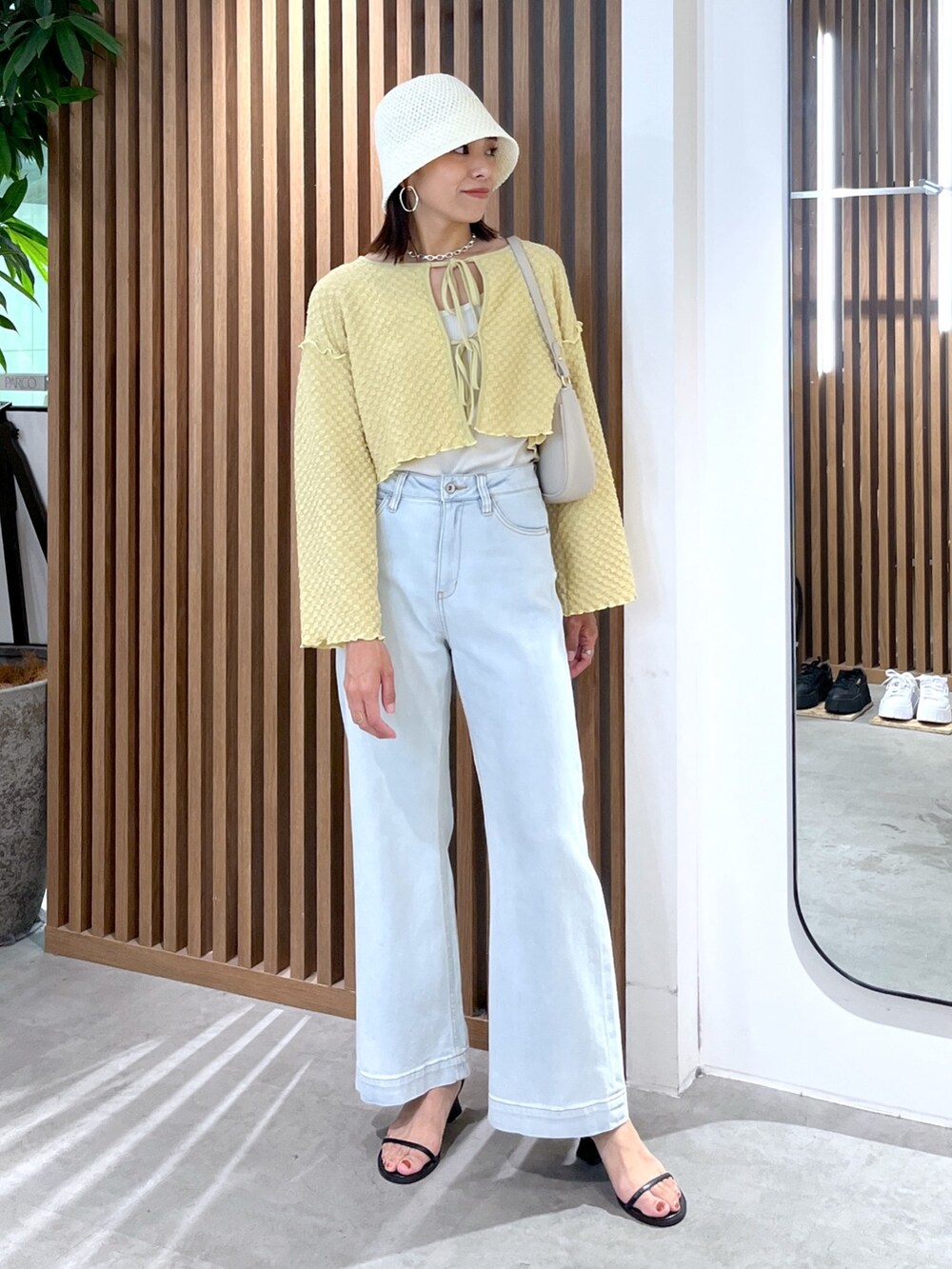 イエロー系のカーディガン/ボレロ、ブルー系のデニムパンツ、グレー系のショルダーバッグを着用したレディースの夏コーディネートの3枚目の写真