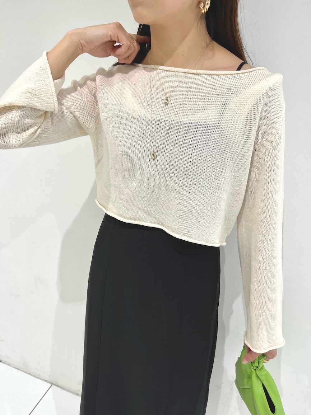 ホワイト系のニット/セーター、ブラック系のワンピース、ブラック系のサンダルを着用したレディースの春コーディネートの5枚目の写真