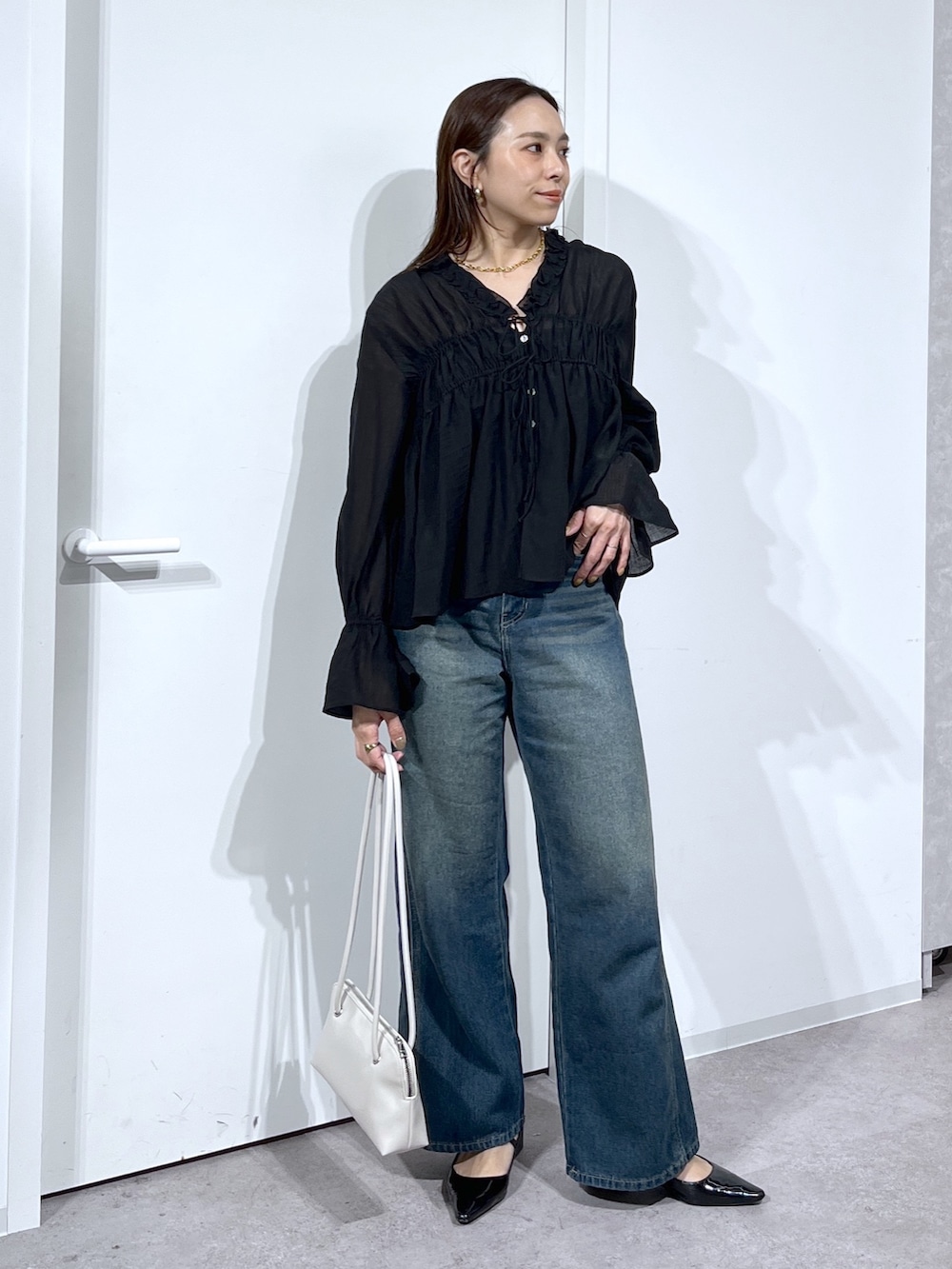 ブラック系のシャツ/ブラウス、ブルー系のデニムパンツを着用したレディースの春コーディネートの9枚目の写真