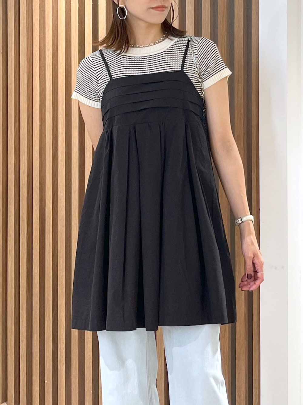 ブラック系のサンダル、ブルー系のデニムパンツ、ブラック系のワンピースを着用したレディースの夏コーディネートの4枚目の写真