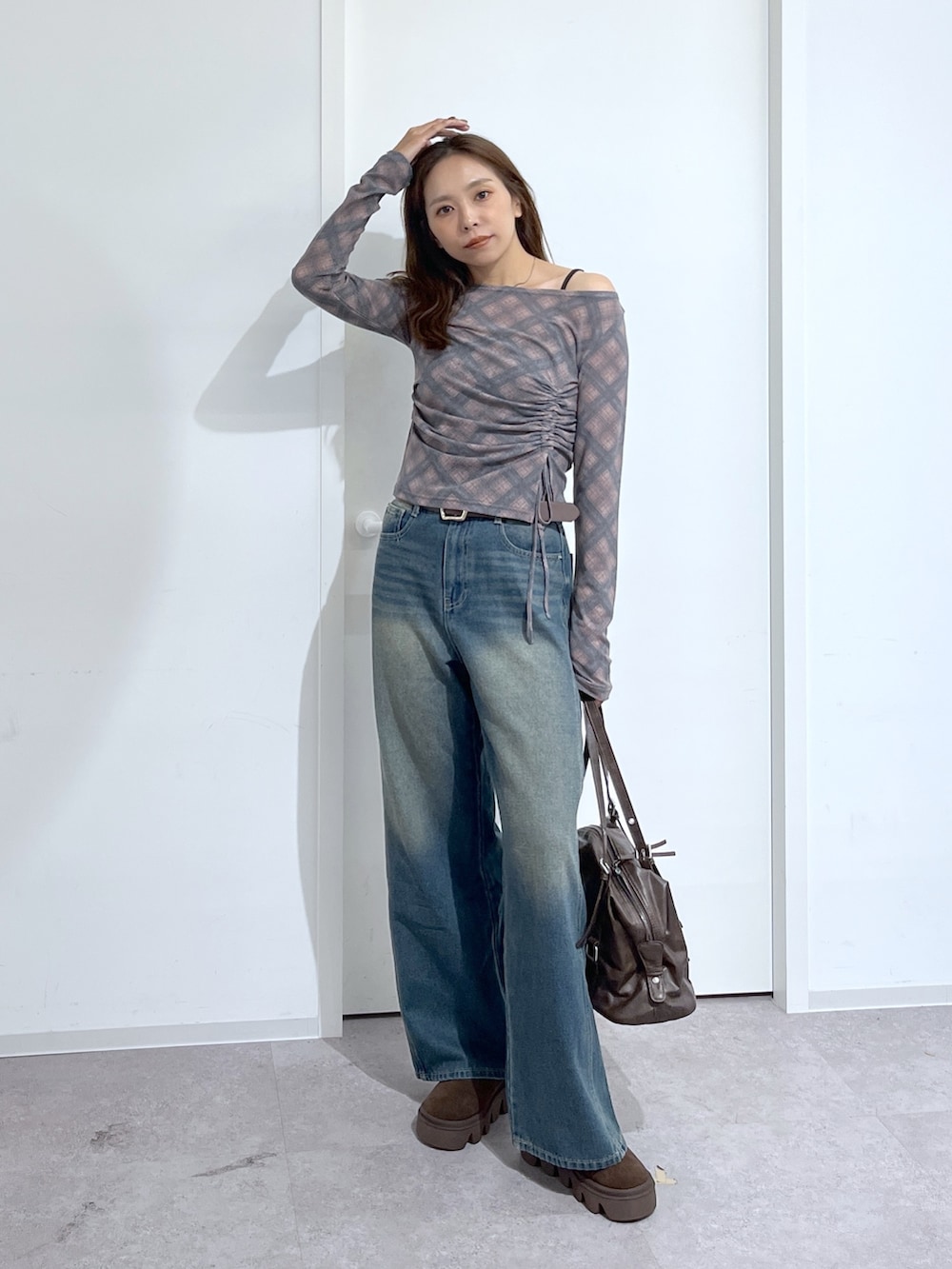 ブラウン系のショルダーバッグ、ブラウン系のTシャツ/カットソー、ブルー系のデニムパンツを着用したレディースの夏コーディネートの7枚目の写真