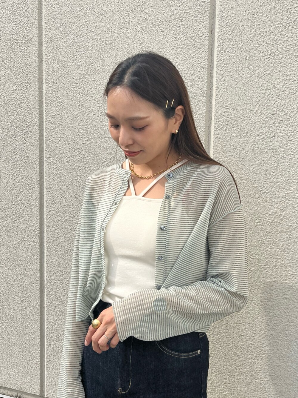 ブルー系のデニムパンツ、ホワイト系のキャミソール、グリーン系のカーディガン/ボレロを着用したレディースの夏コーディネートの3枚目の写真