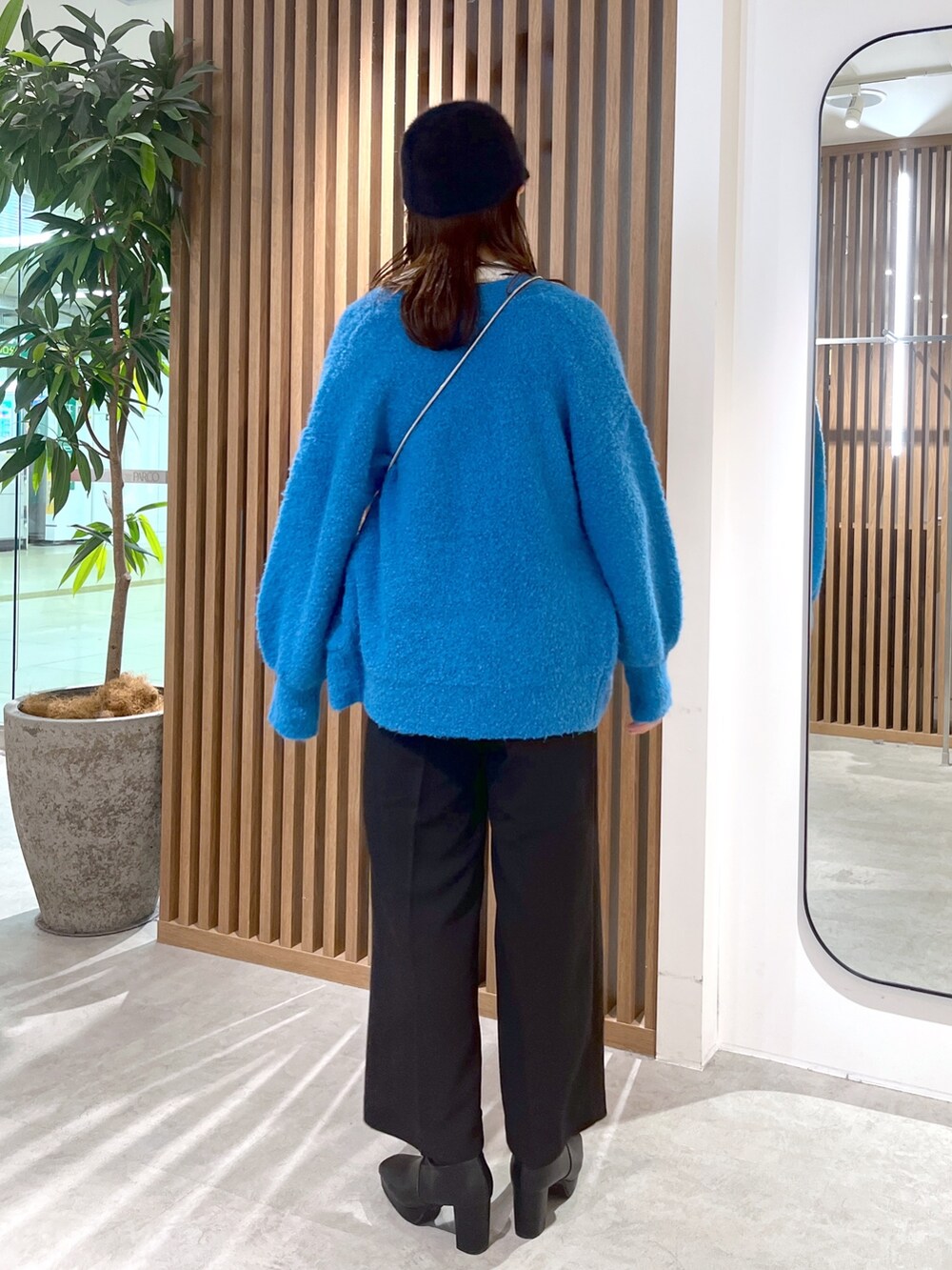 ブルー系のカーディガン/ボレロ、ホワイト系のニット/セーター、ブラック系のスラックスを着用したレディースの秋コーディネートの5枚目の写真