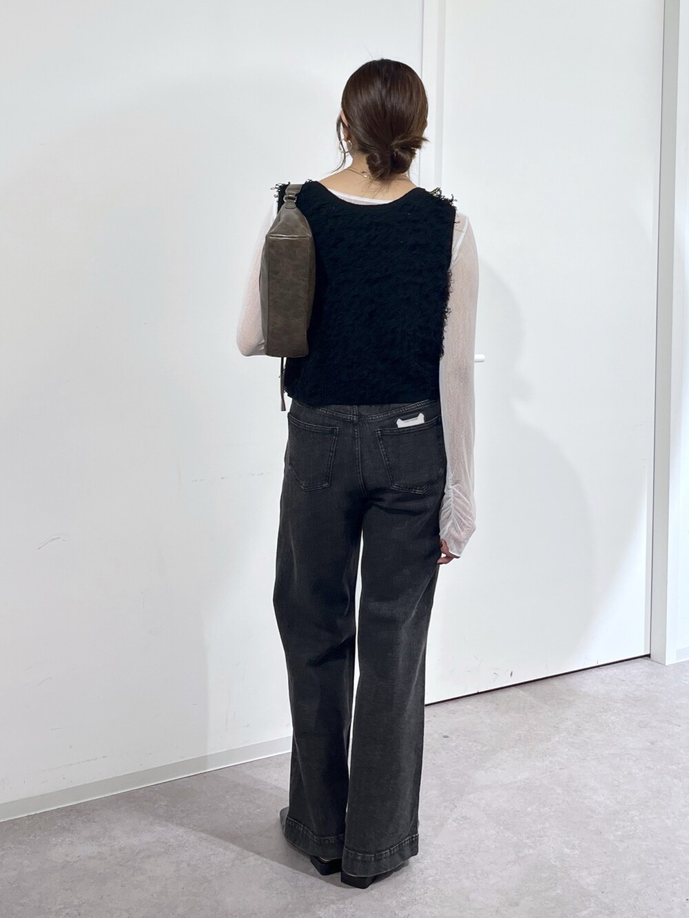 ブラウン系のショルダーバッグ、ブラック系のニット/セーター、ホワイト系のTシャツ/カットソーを着用したレディースの夏コーディネートの5枚目の写真