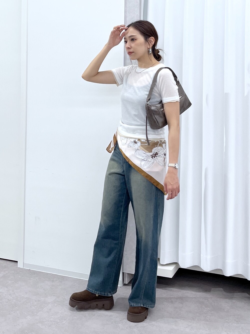 ホワイト系のTシャツ/カットソー、ブラウン系のショルダーバッグ、ブルー系のデニムパンツを着用したレディースの春コーディネートの3枚目の写真