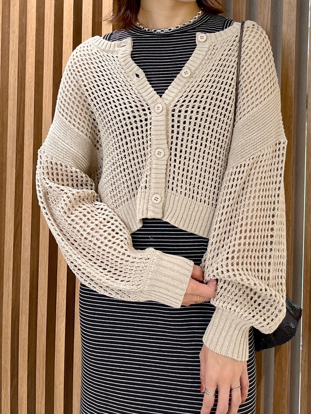 ベージュ系のカーディガン/ボレロ、ブラック系のショルダーバッグ、ブラック系のワンピースを着用したレディースの春コーディネートの7枚目の写真