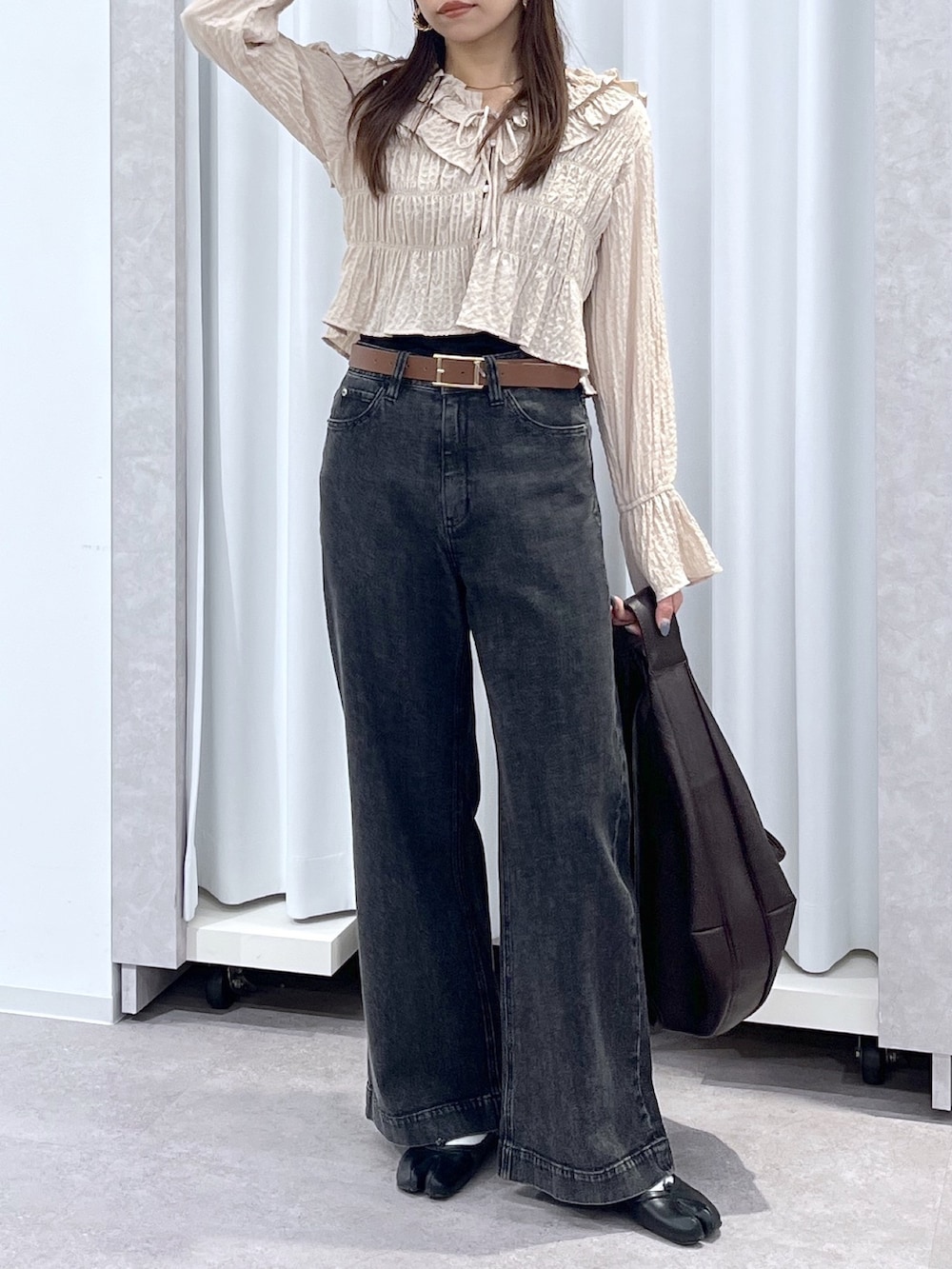 ベージュ系のシャツ/ブラウス、ブラウン系のトートバッグ、ブラック系のデニムパンツを着用したレディースの冬コーディネートの7枚目の写真