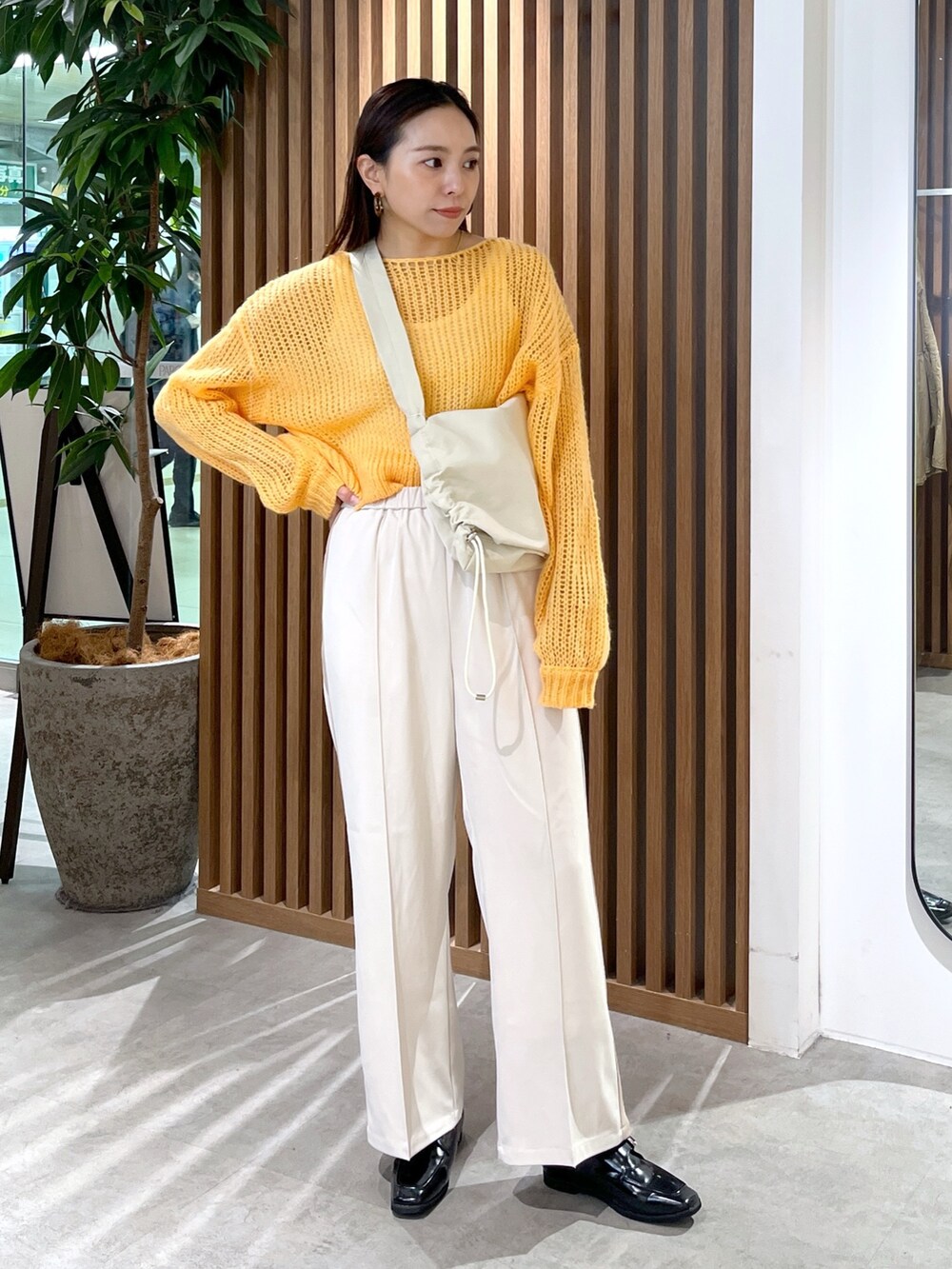 ホワイト系のショルダーバッグ、オレンジ系のニット/セーター、ホワイト系のその他パンツを着用したレディースの冬コーディネートの4枚目の写真