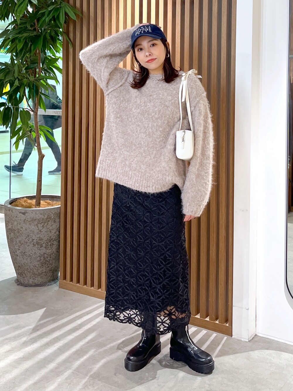 ホワイト系のショルダーバッグ、ベージュ系のニット/セーター、ブラック系のスカートを着用したレディースの冬コーディネートの9枚目の写真