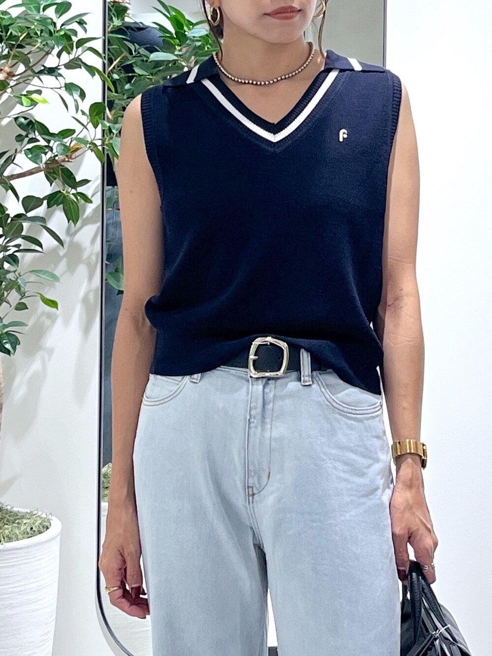 ブルー系のニット/セーター、ブルー系のデニムパンツ、ブラック系のショルダーバッグを着用したレディースの夏コーディネートの8枚目の写真