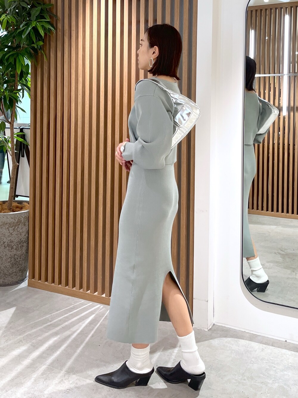 グリーン系のカーディガン/ボレロ、シルバー系のショルダーバッグ、グリーン系のワンピースを着用したレディースの冬コーディネートの4枚目の写真