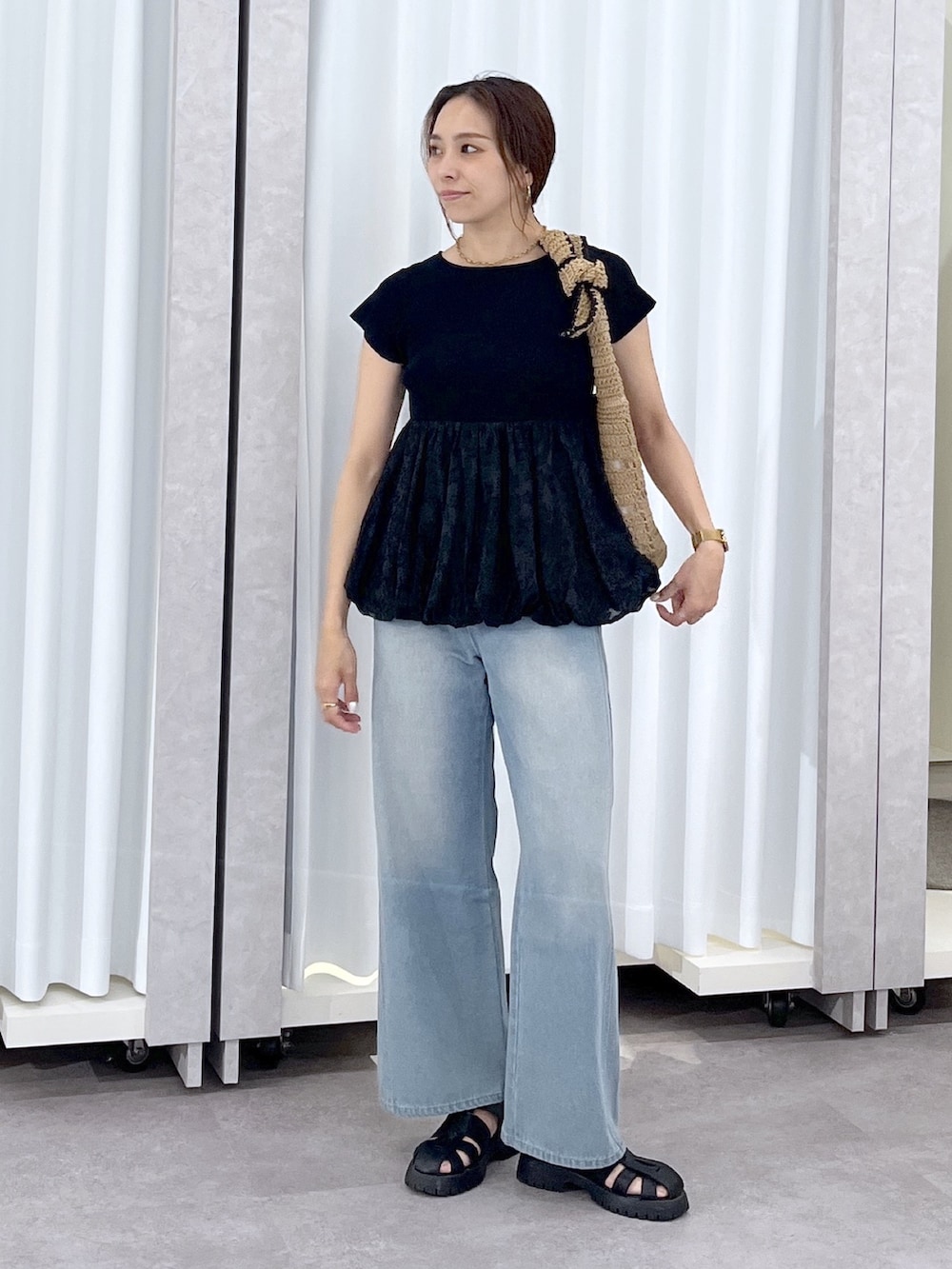 ブルー系のデニムパンツ、ブラック系のニット/セーターを着用したレディースの春コーディネートの9枚目の写真