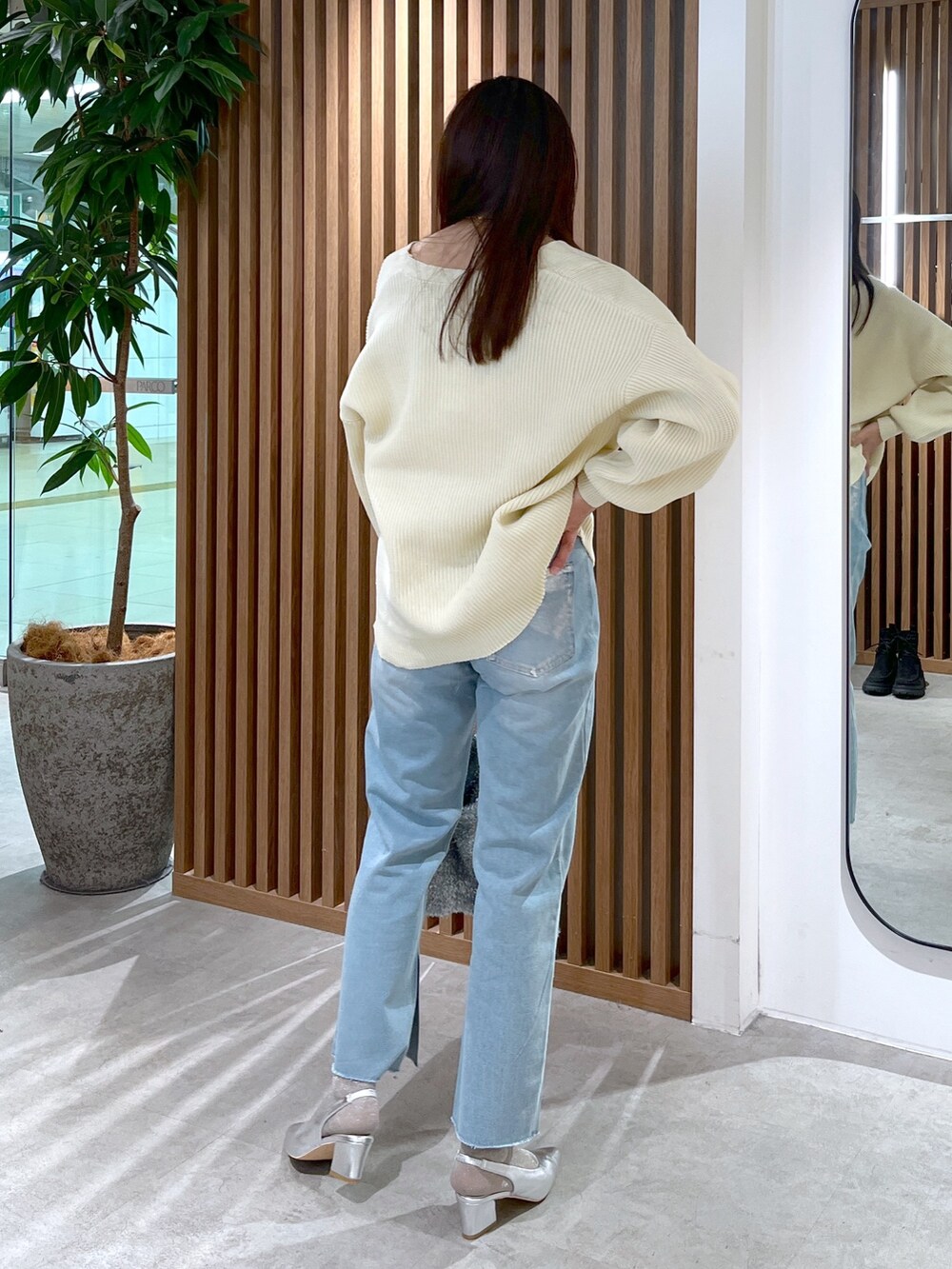 ホワイト系のカーディガン/ボレロ、シルバー系のトートバッグ、ブルー系のデニムパンツを着用したレディースの冬コーディネートの3枚目の写真