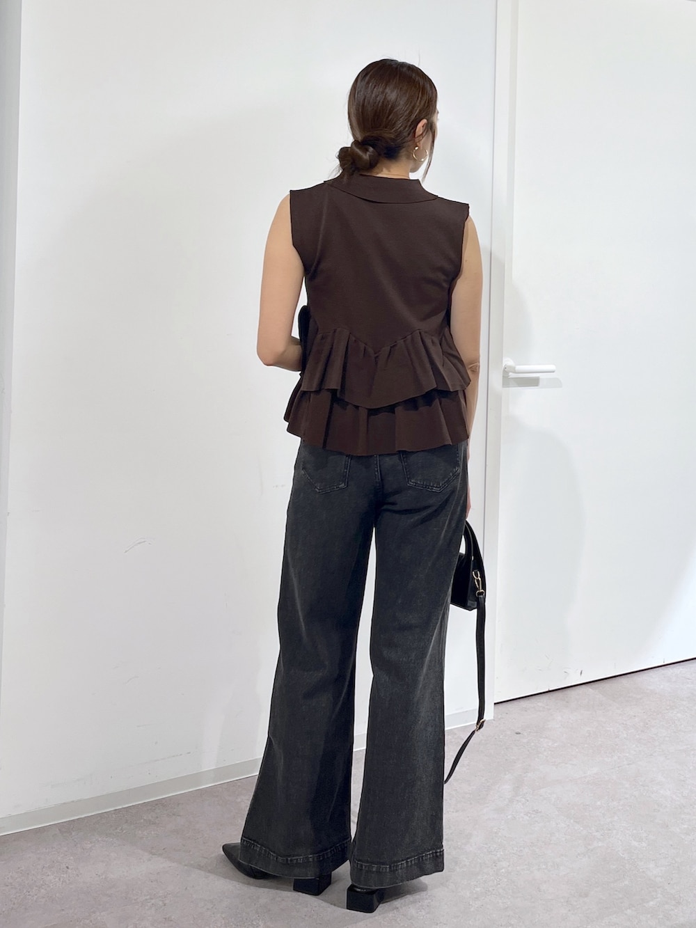 ブラック系のショルダーバッグ、ブラウン系のニット/セーター、ブラック系のデニムパンツを着用したレディースの夏コーディネートの5枚目の写真