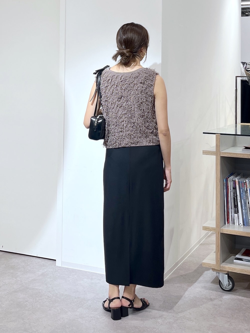 ブラック系のショルダーバッグ、ブラウン系のニット/セーター、ブラック系のワンピースを着用したレディースの夏コーディネートの7枚目の写真