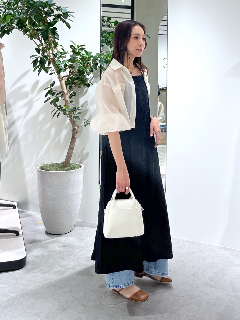 ホワイト系のシャツ/ブラウス、ブラック系のワンピース、ホワイト系のトートバッグを着用したレディースの春コーディネートの6枚目の写真