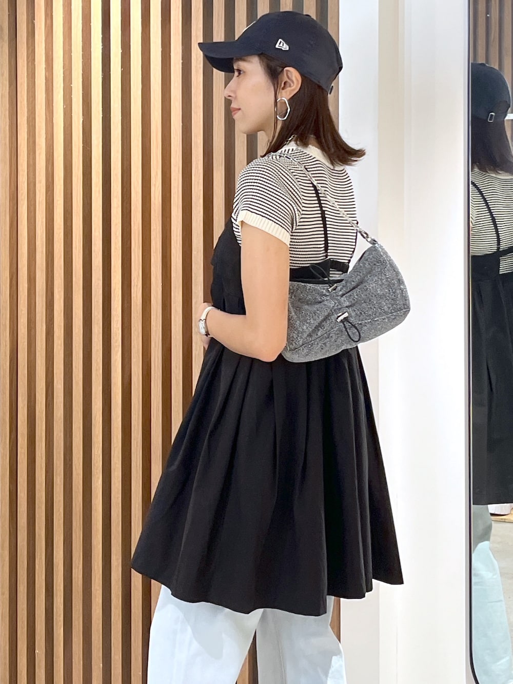 ブラック系のサンダル、ブルー系のデニムパンツ、ブラック系のワンピースを着用したレディースの夏コーディネートの5枚目の写真