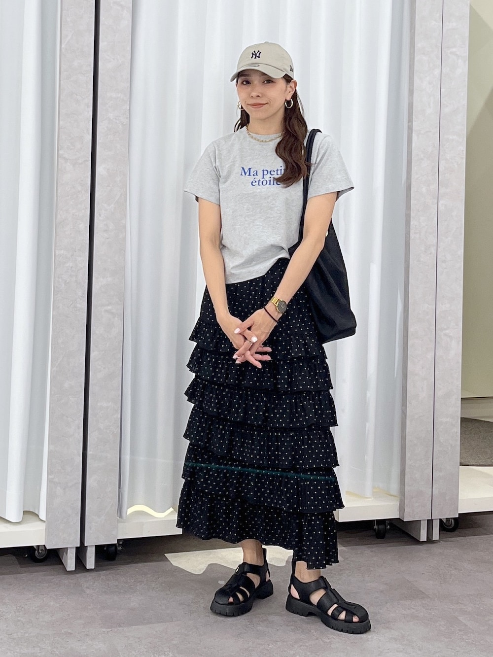 ブラック系のトートバッグ、ブラック系のスカート、グレー系のTシャツ/カットソーを着用したレディースの春コーディネートの5枚目の写真