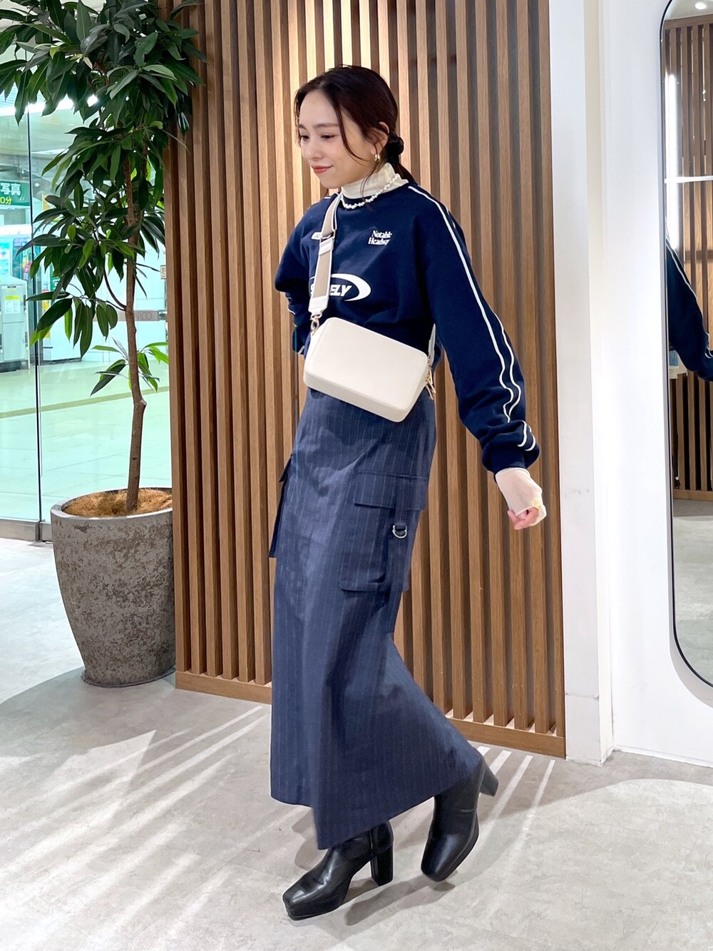 ホワイト系のTシャツ/カットソー、ホワイト系のショルダーバッグ、ブルー系のスウェットを着用したレディースの冬コーディネートの4枚目の写真