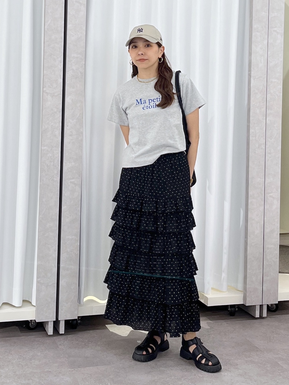 ブラック系のトートバッグ、ブラック系のスカート、グレー系のTシャツ/カットソーを着用したレディースの春コーディネートの2枚目の写真