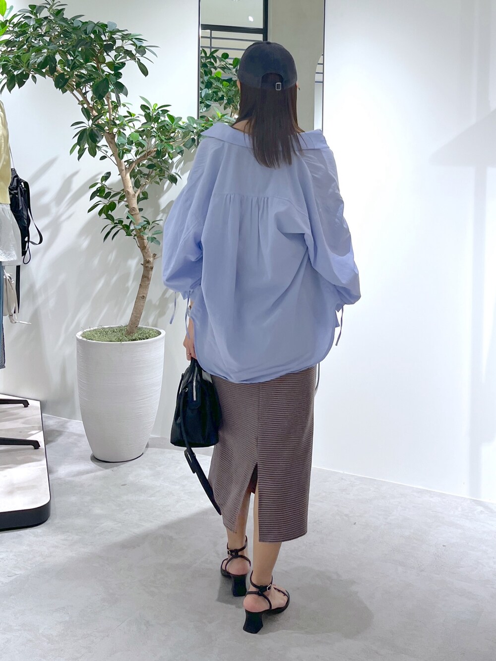 ブラウン系のワンピース、ブルー系のシャツ/ブラウス、ブラック系のショルダーバッグを着用したレディースの春コーディネートの7枚目の写真