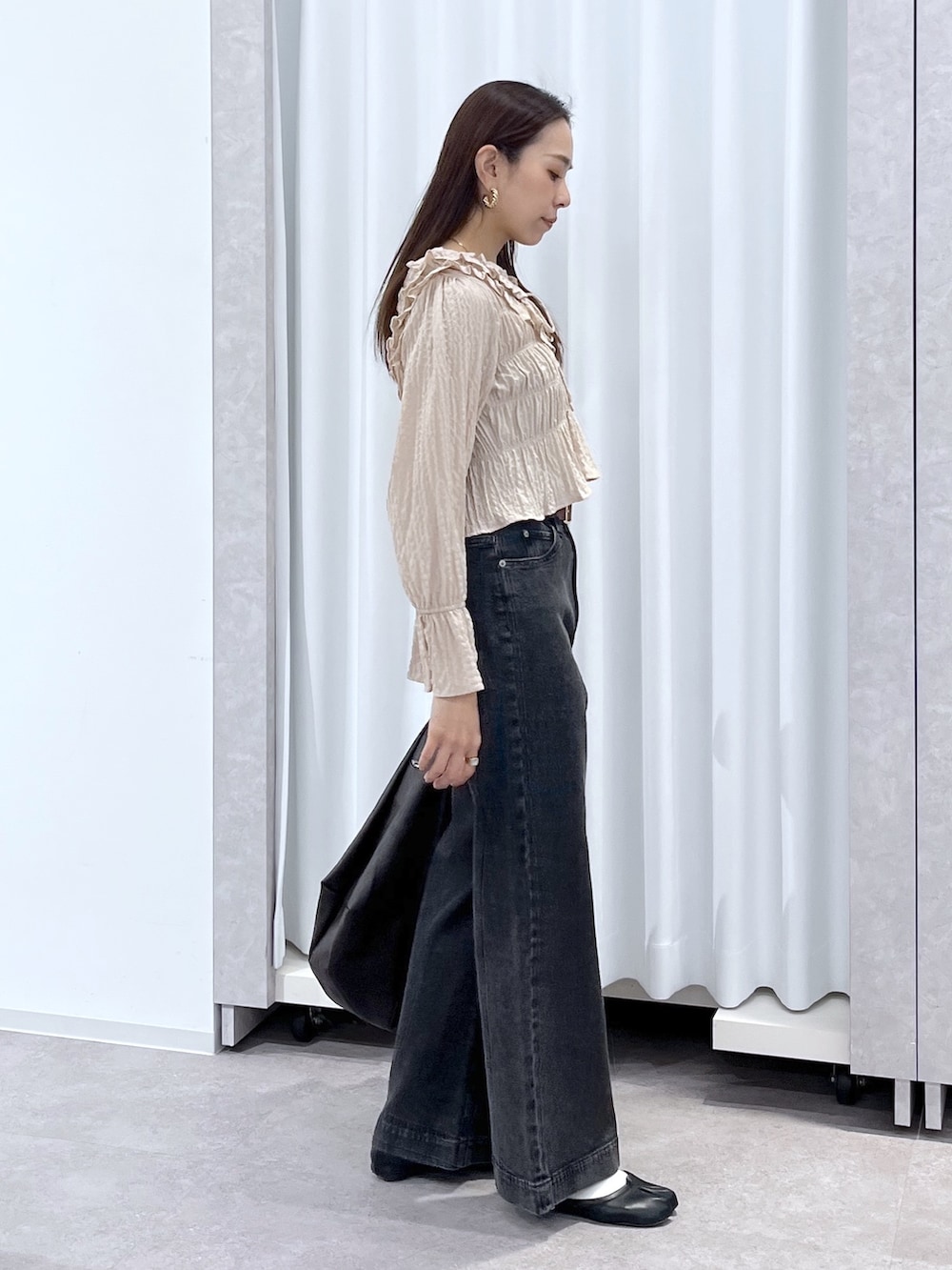 ベージュ系のシャツ/ブラウス、ブラウン系のトートバッグ、ブラック系のデニムパンツを着用したレディースの冬コーディネートの6枚目の写真