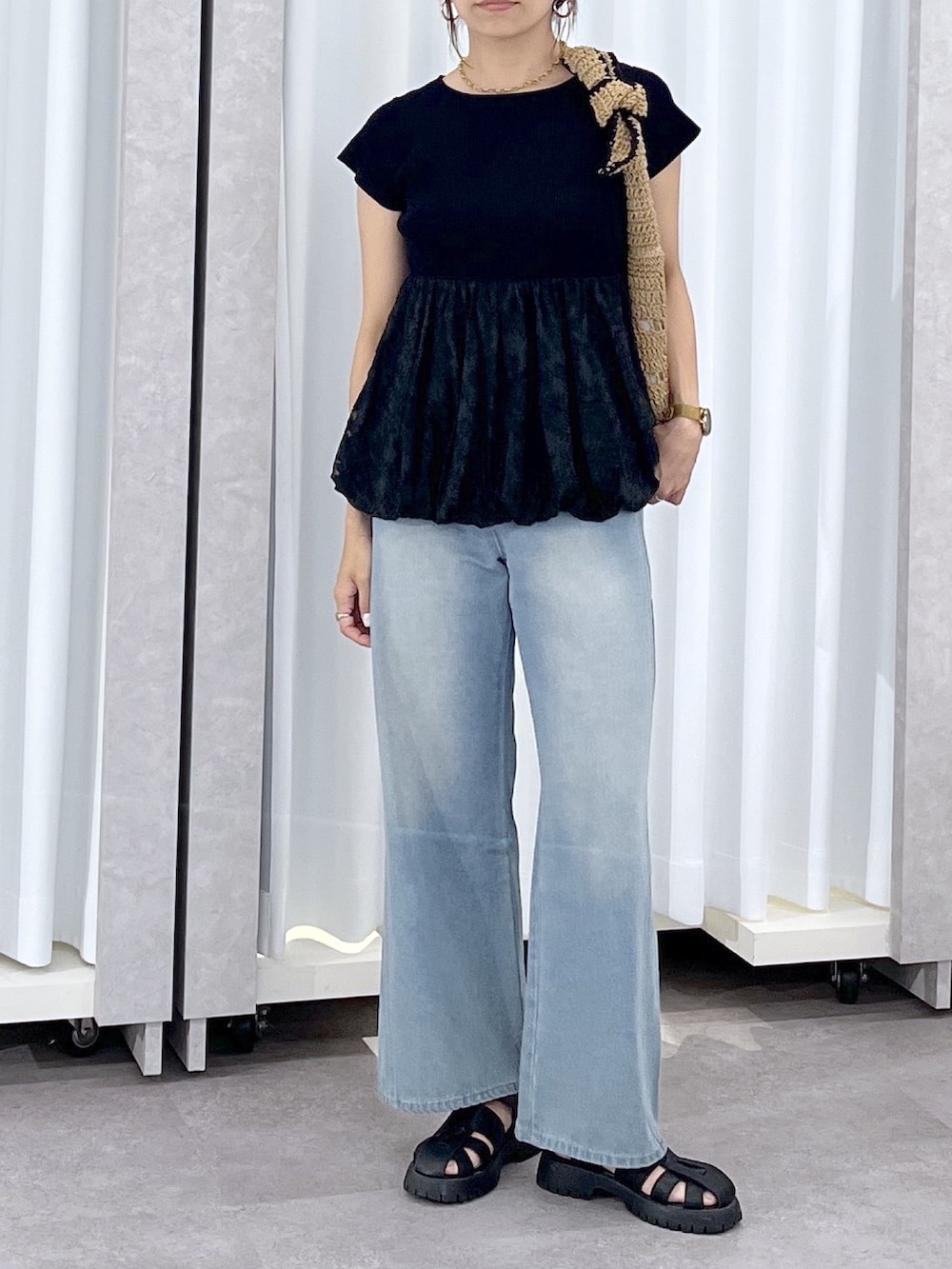 ブルー系のデニムパンツ、ブラック系のニット/セーターを着用したレディースの春コーディネートの7枚目の写真