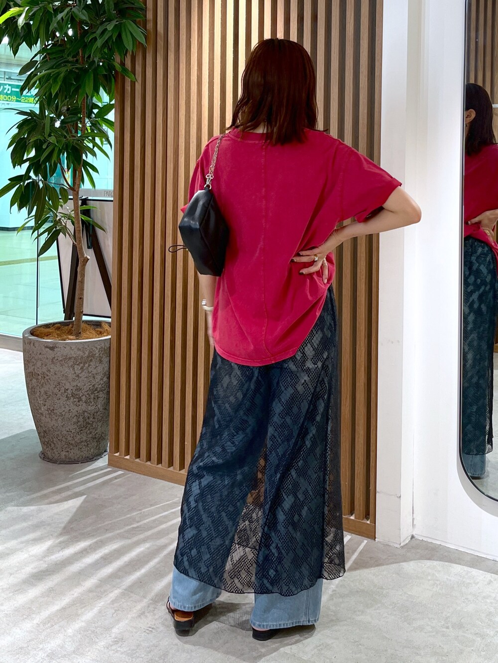 レッド系のTシャツ/カットソー、ブラック系のハンドバッグ、ブルー系のデニムパンツを着用したレディースの夏コーディネートの5枚目の写真