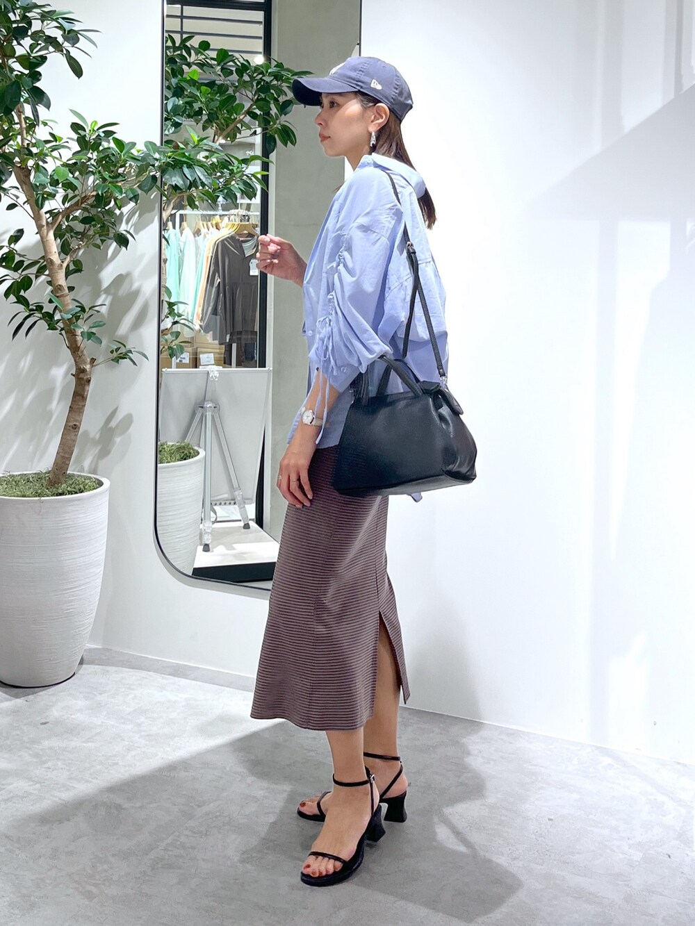 ブラウン系のワンピース、ブルー系のシャツ/ブラウス、ブラック系のショルダーバッグを着用したレディースの春コーディネートの8枚目の写真
