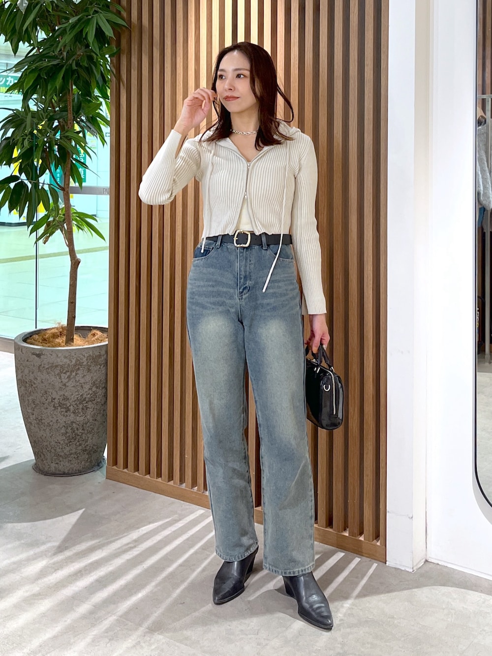 ホワイト系のニット/セーター、ベージュ系のテーラードジャケット、ブルー系のデニムパンツを着用したレディースの冬コーディネートの9枚目の写真