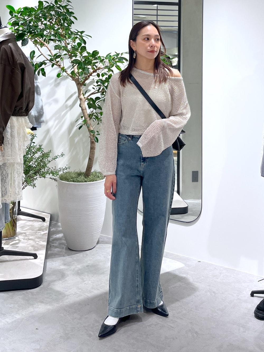 ホワイト系のニット/セーター、ホワイト系のキャミソール、ブラック系のショルダーバッグを着用したレディースの春コーディネートの3枚目の写真