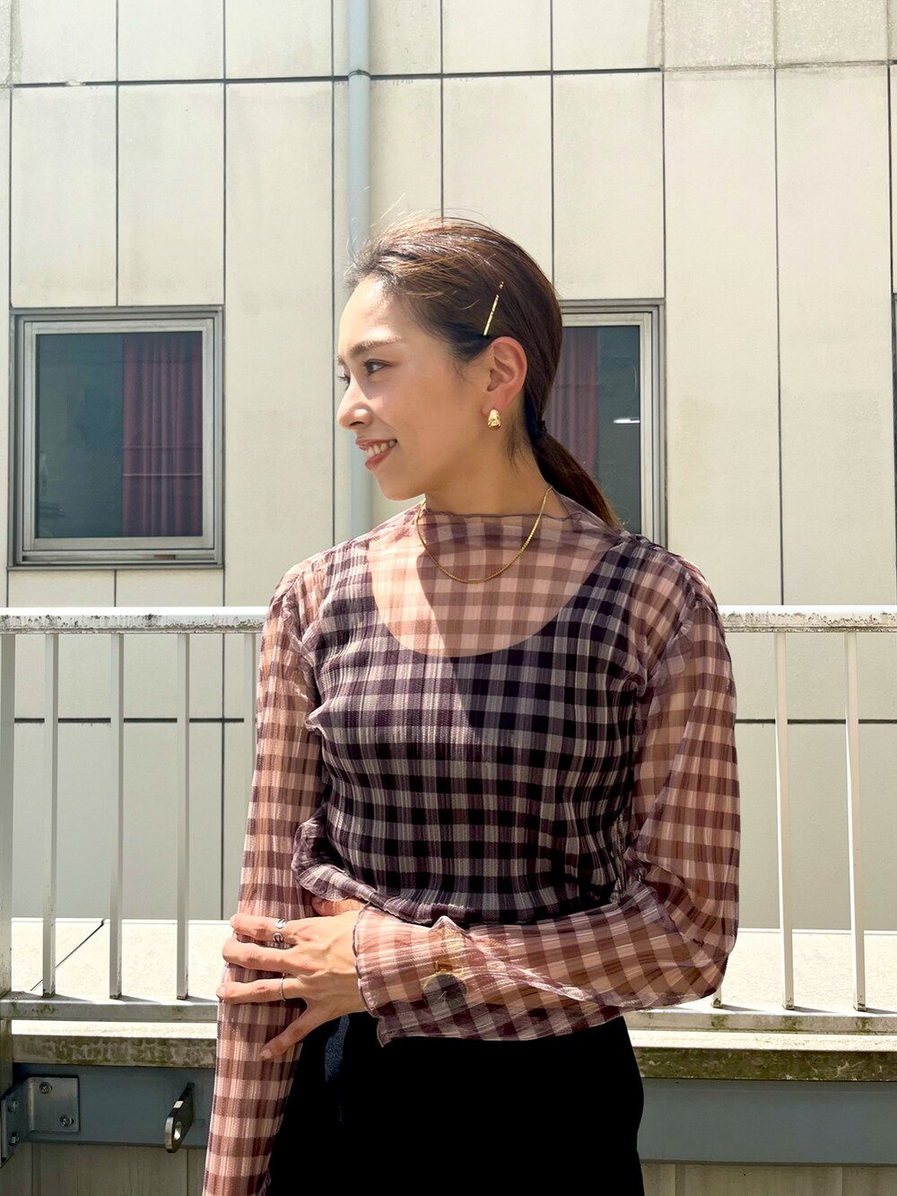 ブラウン系のTシャツ/カットソー、ブラック系のスカート、ブラック系のローファーを着用したレディースの夏コーディネートの3枚目の写真