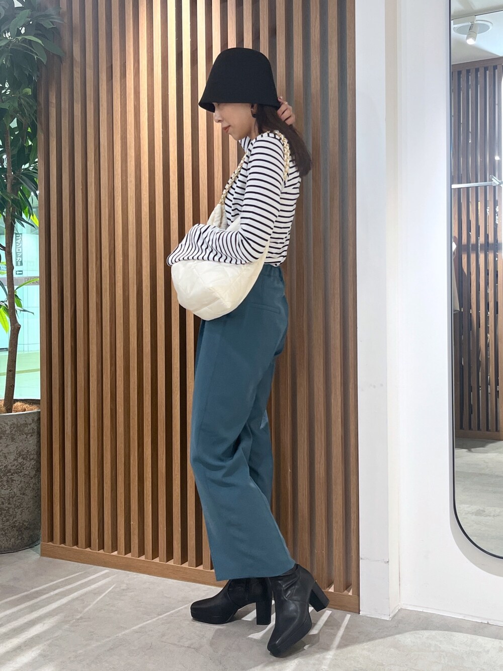 グリーン系のスラックス、ブラック系のTシャツ/カットソー、ホワイト系のトートバッグを着用したレディースの秋コーディネートの3枚目の写真