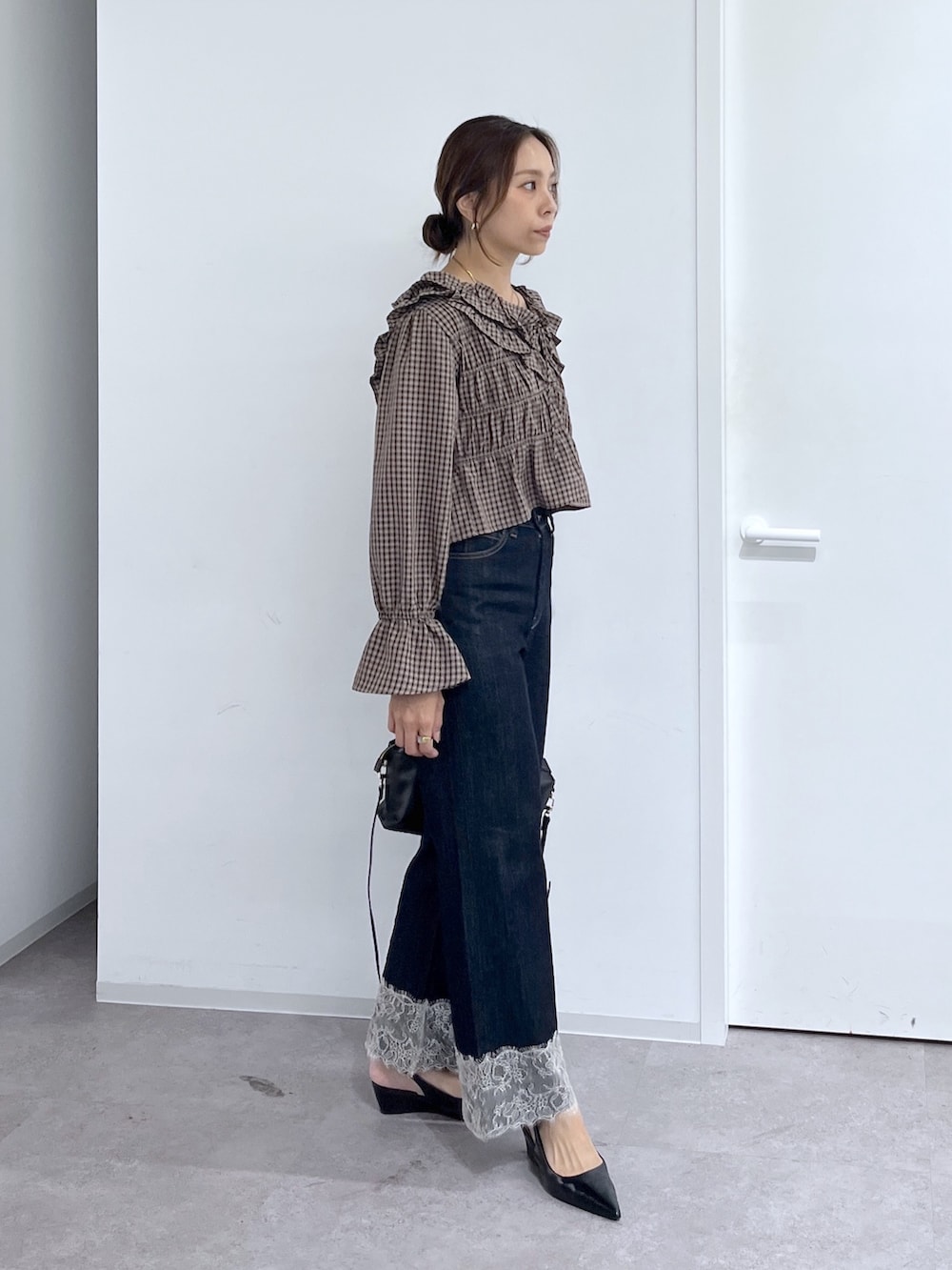 ブルー系のデニムパンツ、ブラック系のハンドバッグ、ブラウン系のシャツ/ブラウスを着用したレディースの秋コーディネートの7枚目の写真