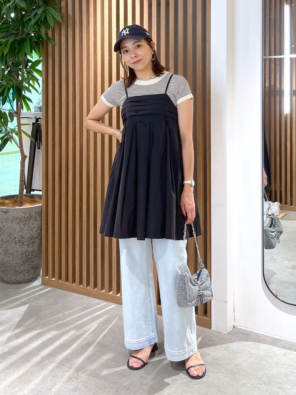 ブラック系のサンダル、ブルー系のデニムパンツ、ブラック系のワンピースを着用したレディースの夏コーディネートの8枚目の写真