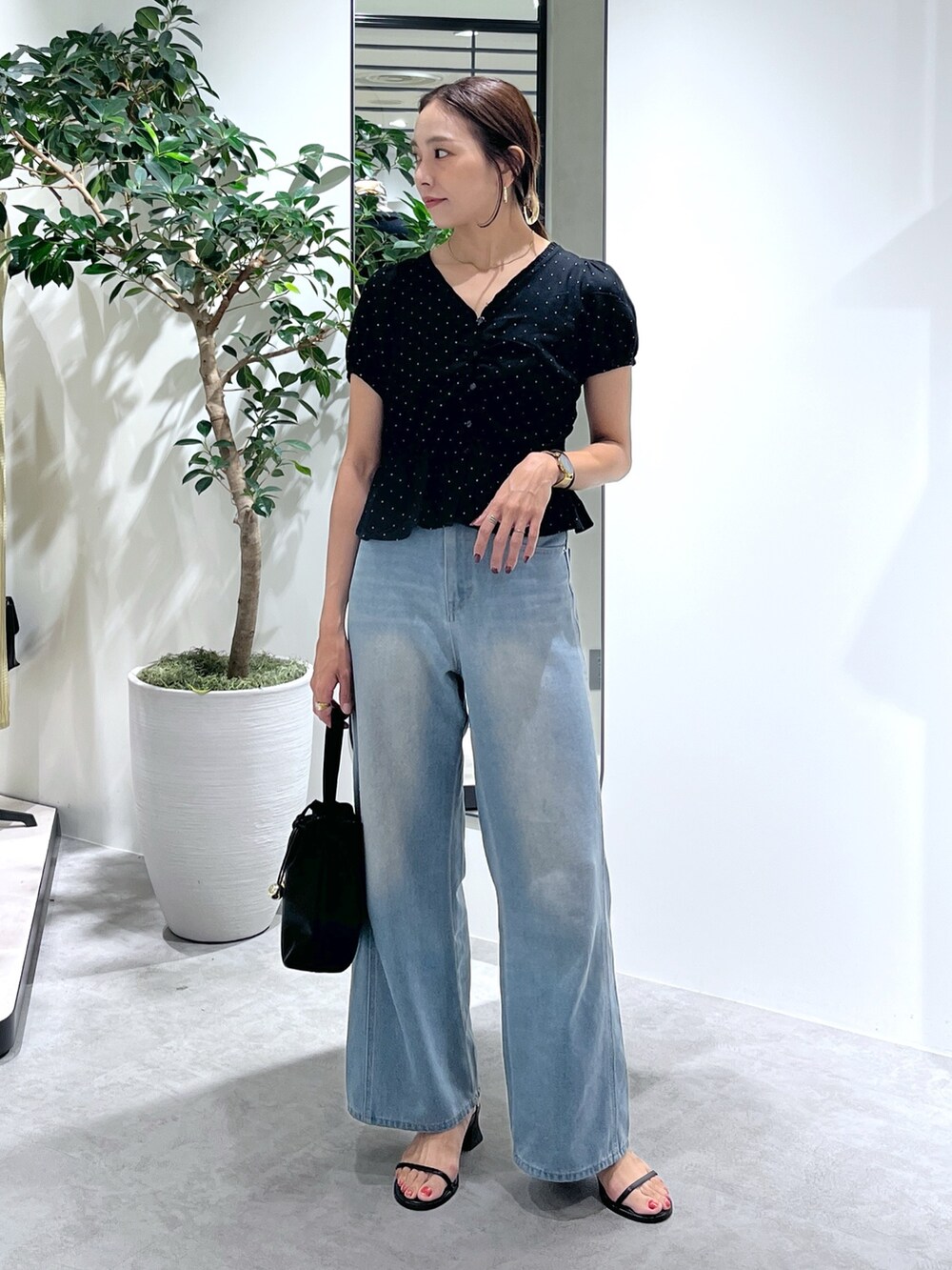 ブラック系のショルダーバッグ、ブルー系のデニムパンツ、ブラック系のシャツ/ブラウスを着用したレディースの夏コーディネートの2枚目の写真